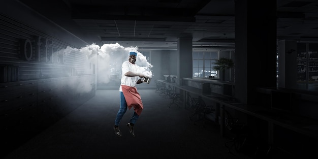 Photo joyful black man wearing an apron and cooking in action. mixed media