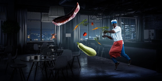Foto uomo di colore gioioso che indossa un grembiule e cucina in azione. tecnica mista