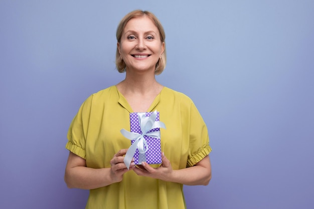 Gioiosa donna di mezza età bionda ha ricevuto il suo regalo di compleanno