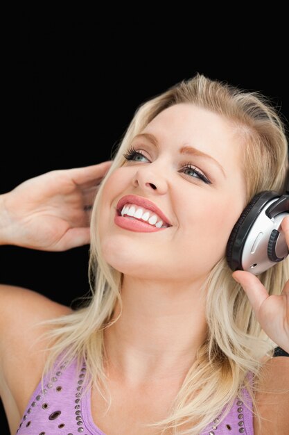 Joyful blonde woman listening to music