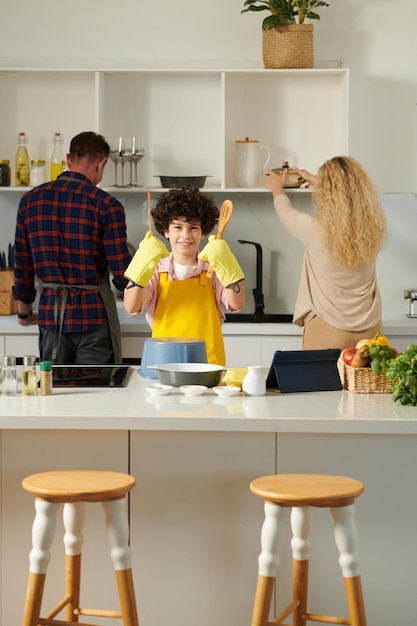 Photo joyful boy playing on saucepan