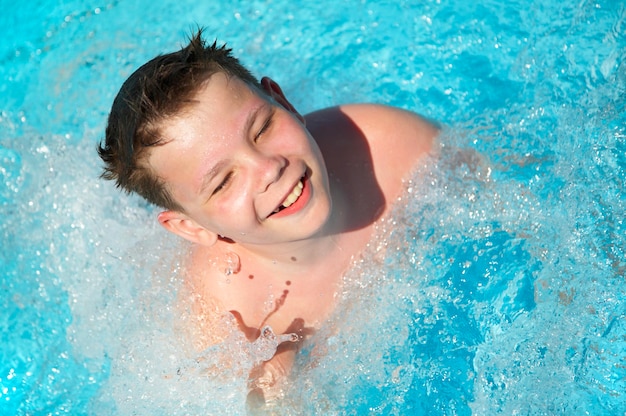 Радостный мальчик в бассейне