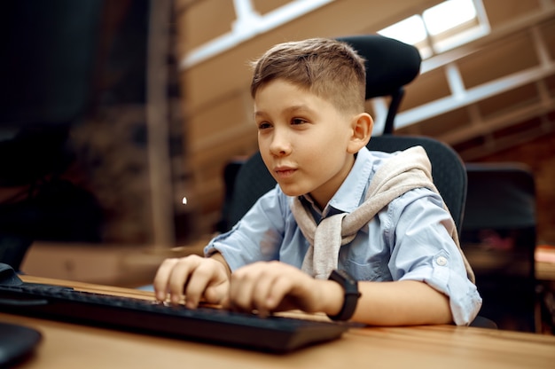 Joyful boy works on PC, little blogger. Kid blogging in home studio, social media for young audience, online internet broadcast, creative hobby