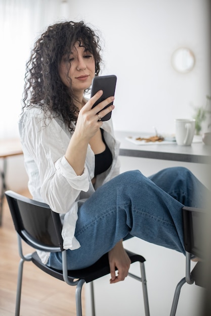 Joyful brunette woman chatting surfing internet use smartphone enjoying coffee break at cafe