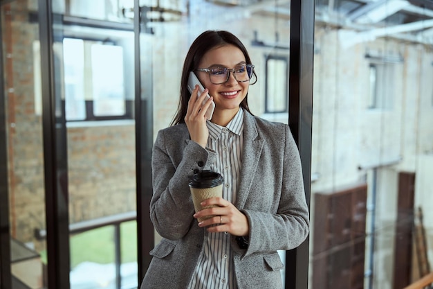 Joyful brunette woman spending her break in the hall