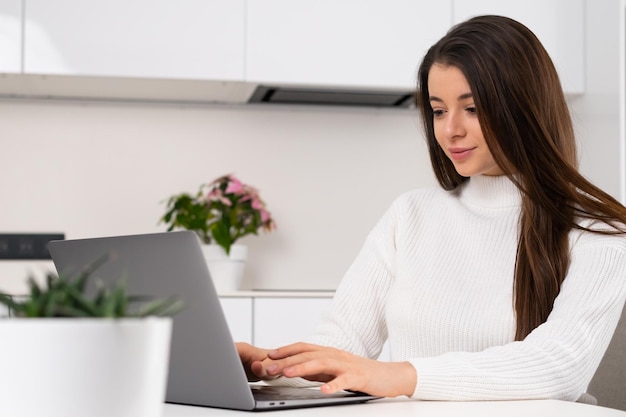 Gioiosa donna d'affari che lavora a casa utilizzando un computer portatile