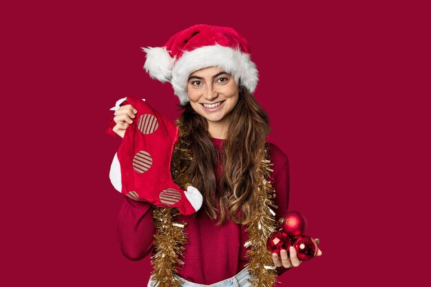 Photo joyful caucasian woman with christmas stocking and hat