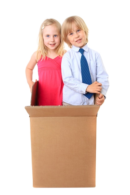 Joyful children look out from a cardboard box.