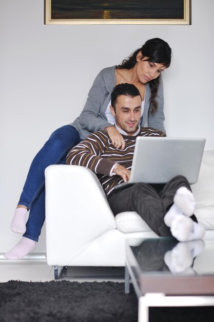 joyful couple relax and work on laptop computer at modern living room indoor home