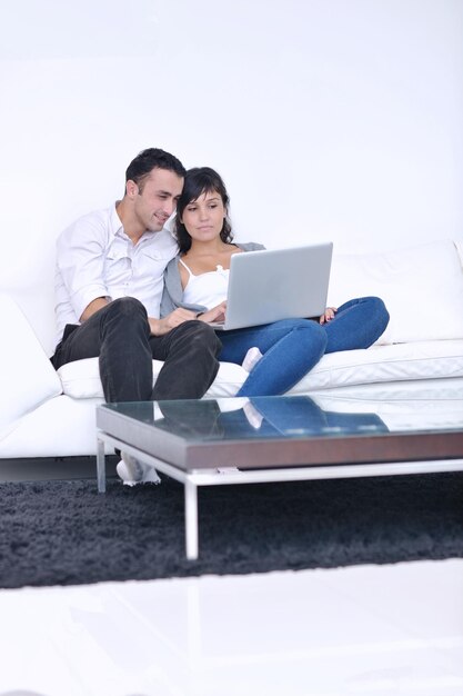 joyful couple relax and work on laptop computer at modern living room indoor home