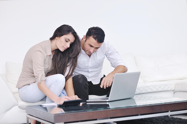 joyful couple relax and work on laptop computer at modern living room indoor home