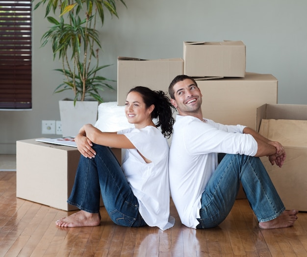 Joyful couple with unpacking boxes moving to a new house