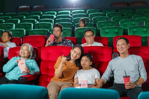 写真 楽しい家族映画時間 アジアの両親と子供がポップコーンで映画を見ている