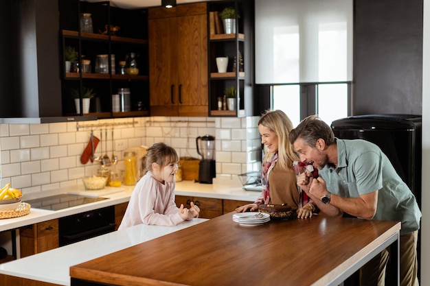 Joyful Family Enjoying Homemade Chocolate Cake in Cozy Kitchen