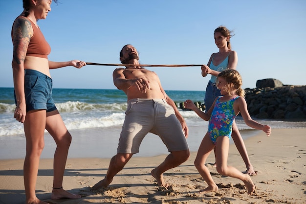 Foto famiglia gioiosa in limbo sulla spiaggia sabbiosa