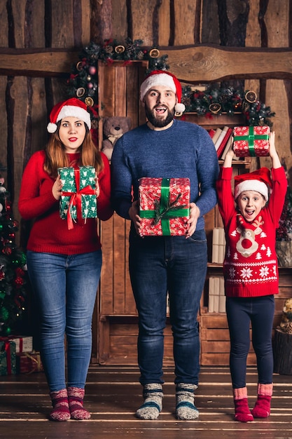 Joyful family with gifts in their hands for Christmas