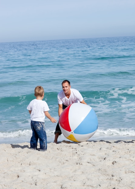 幸せな父と彼の息子はボールで遊んでいる