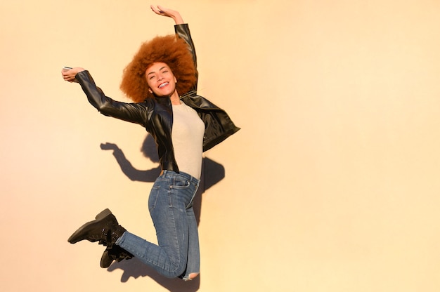 Радостная и веселая счастливая женщина прыгает с мобильным телефоном в руке