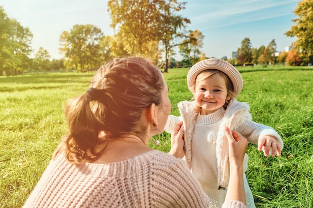 Joyful girl child caucasian runs to mom in the park.