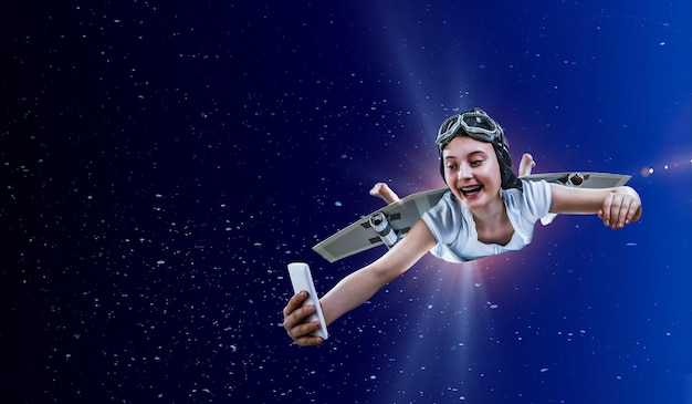 自作の紙の翼で宇宙を飛んでいるうれしそうな女の子。ミクストメディア