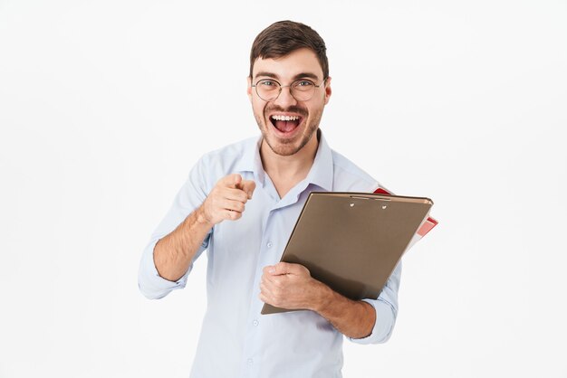 joyful handsome man holding file with documents and pointing finger at front isolated over white wall