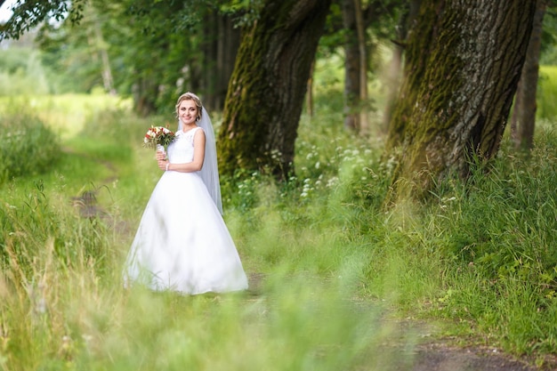 Joyful and happy bride in an oak grove