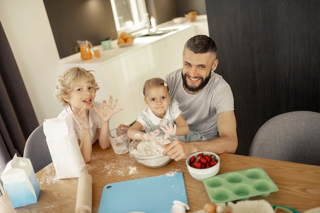 Gioioso uomo felice seduto con i suoi figli