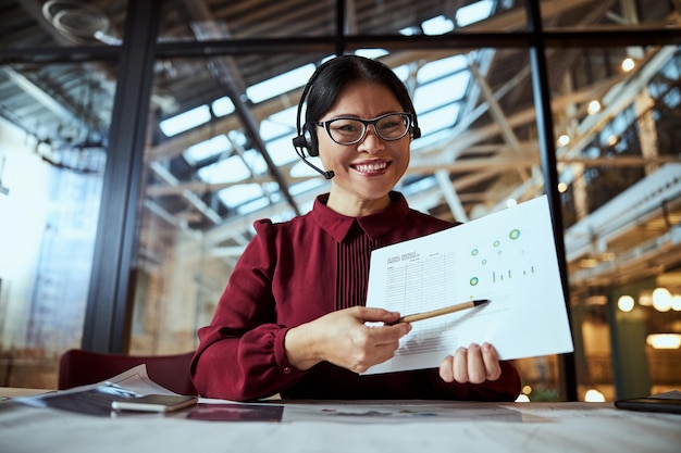 Joyful international female pointing at her scheme