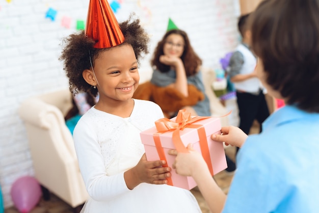 Joyful little girl is waiting gift for birthday.