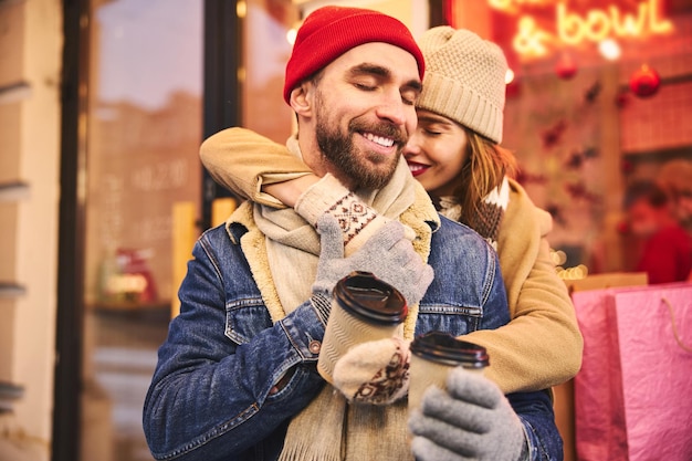 Joyful loving couple dating on cold day in city