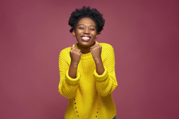 Joyful lucky young african american girl winner feeling triumph rejoicing goal achievement fortune