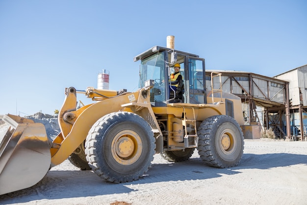 Joyful man driving industrial truck at factory