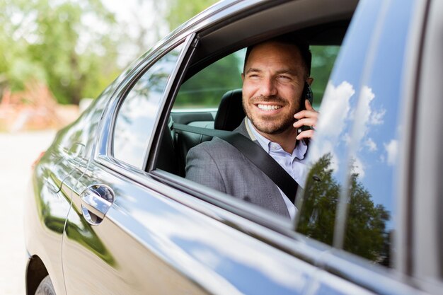 Photo joyful man sharing laughter on a phone call while driving in daylight