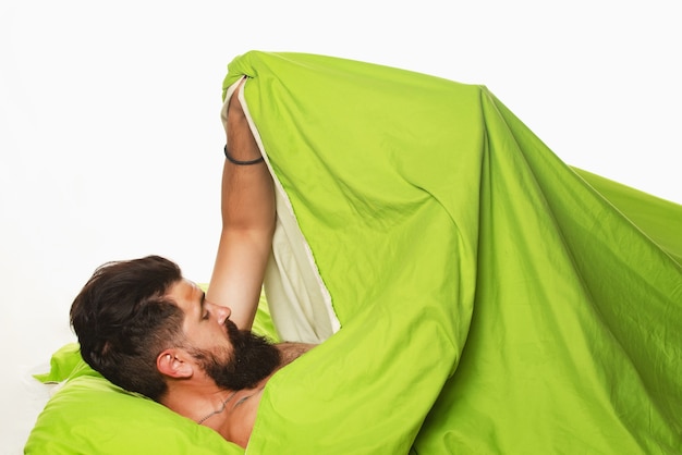 Joyful man sleeping on a bed