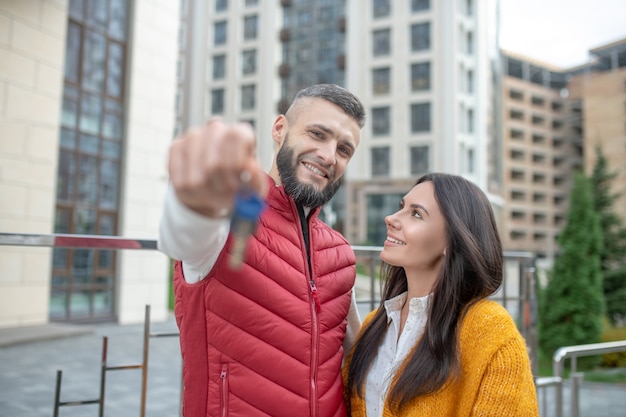 Joyful married couple standing together while moving to a new house