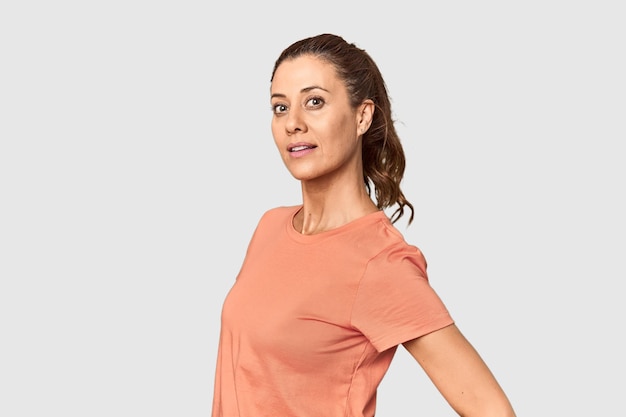 Joyful middleaged woman posing contentedly in studio