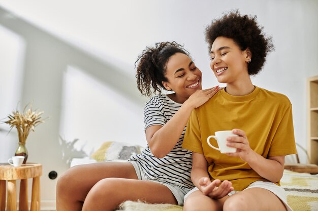a joyful moment between two women at home enjoying coffee and laughter together