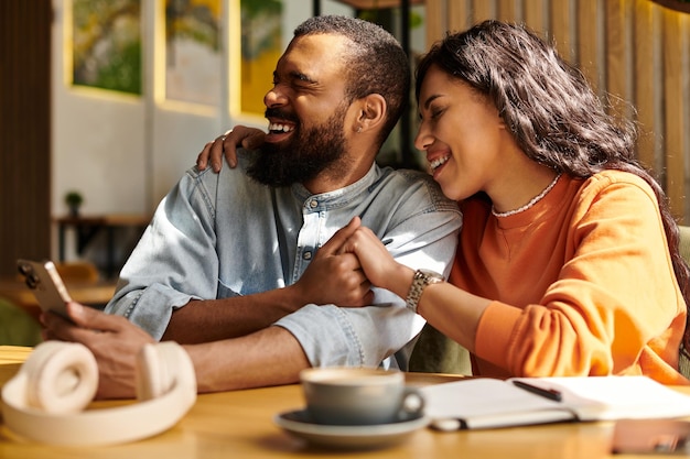 Joyful moments shared by an African American couple in a cozy cafe setting