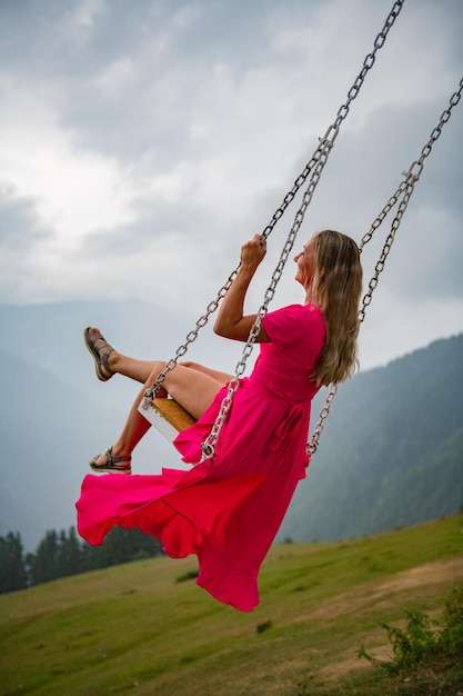 Foto momenti di gioia su un'altalena una ragazza con un vestito rosa su un'allantana