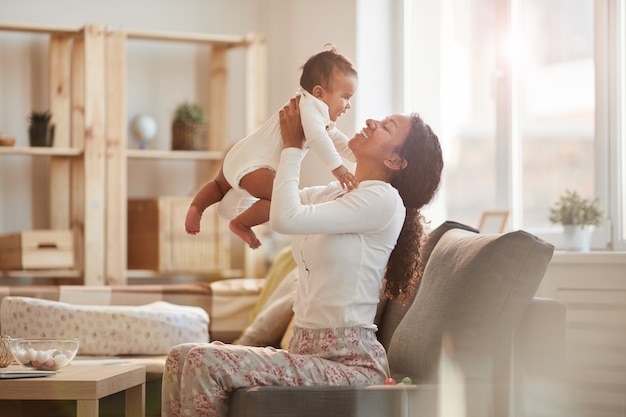 joyful mother playing with baby