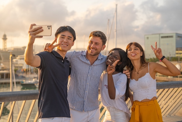 Joyful multiracial friends taking selfie on quay