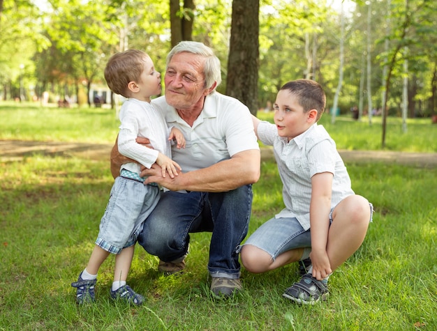 Joyful nice loving grandsons hugging and kissing his grandfather. Life