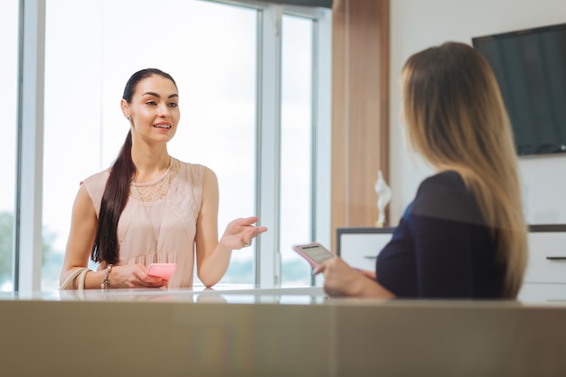 写真 約束をしながら管理者と話しているうれしそうな楽しい女性