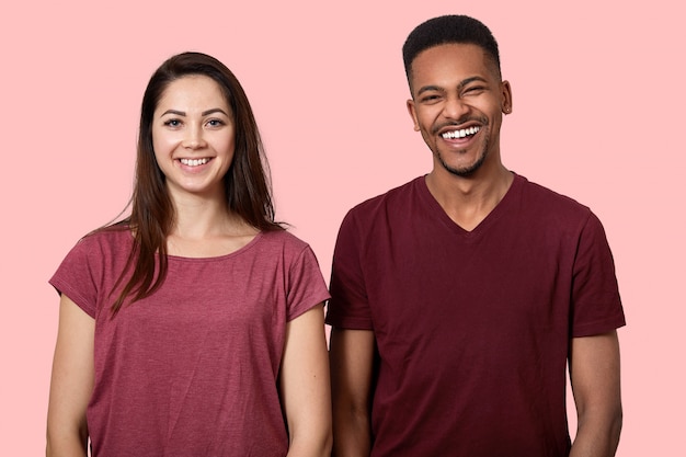 Joyful positive African American man and woman smile broadly at camera