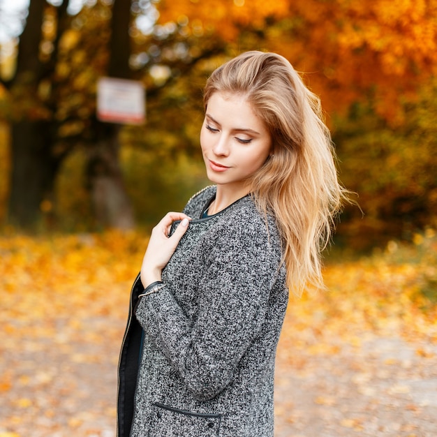 Joyful pretty beautiful young woman with trendy gray coat