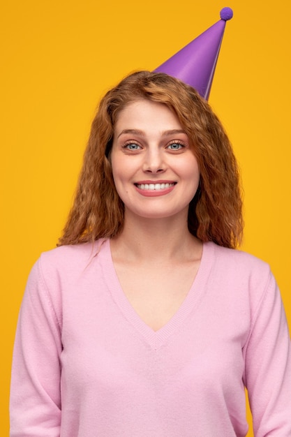 Joyful redhead woman in party hat