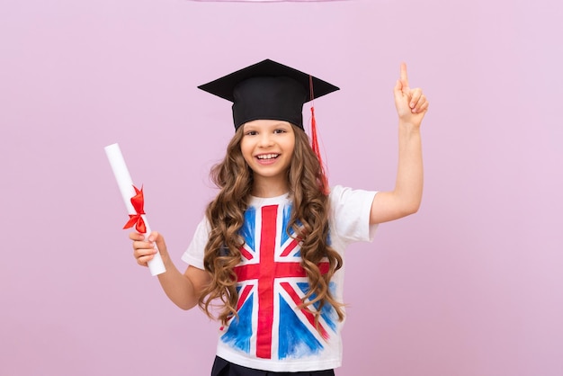 A joyful schoolgirl with a certificate and a ceremonial hat of
a graduate a student in a tshirt with an english flag learning
foreign languages a schoolgirl points her finger at an
advertisement