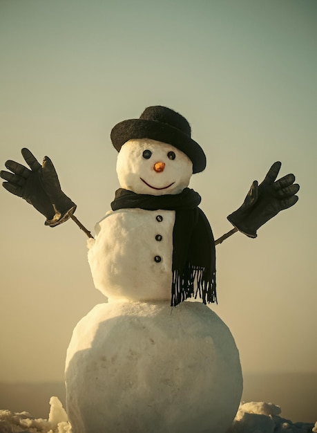 うれしそうな雪だるま冬の黒い帽子のスカーフと手袋の雪だるま紳士