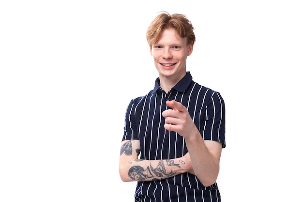 joyful stylish young blond guy in a striped polo shirt with a tattoo on a white background