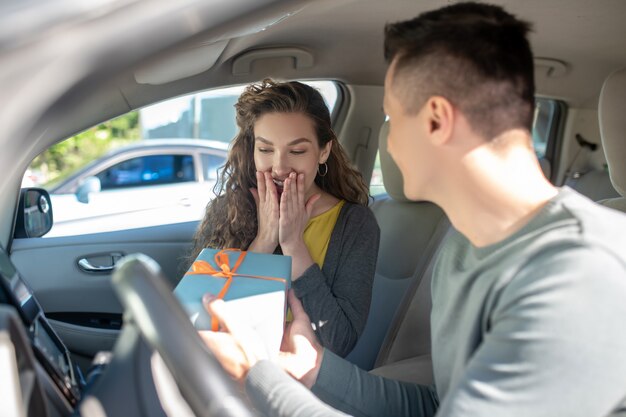 うれしそうな驚きの女性と車のボックスを持つ男